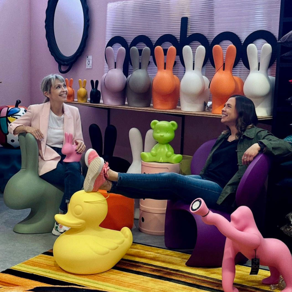 Anne et Marion Gillet présentant la collection de sièges et objets design Qeeboo dans leur boutique. Entourées de chaises lapin, canard géant, et autres créations colorées, elles stimulent la créativité et l'originalité de notre sélection de mobilier unique. Découvrez des pièces ludiques et tendance pour votre intérieur chez Manufacture Dubosc et Fils.