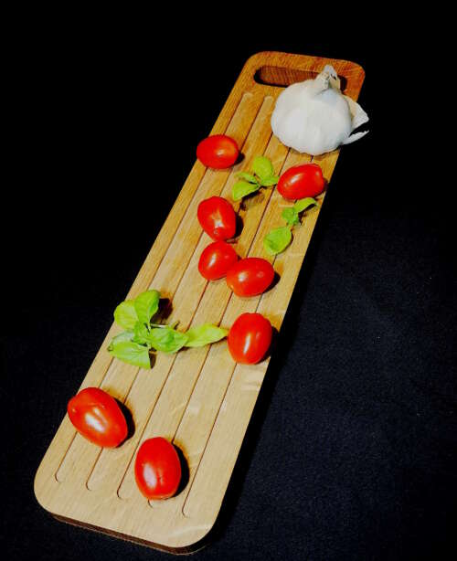 Planche de présentation en bois durable éco-responsable de Manufacture Dubosc et Fils, garnie de tomates, basilic et ail. Accessoire en bois fait main, issu de l'artisanat local, conçu avec des matériaux recyclés pour une qualité supérieure. Design intemporel et fabrication artisanale reflétant un savoir-faire traditionnel, idéal pour une conception personnalisée et une cuisine zéro déchet.