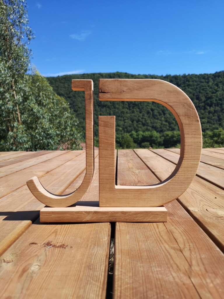 Lettrage représentant les initiales 'JD', réalisée par Manufacture Dubosc et Fils. Création artisanale sur-mesure en chêne, idéale pour la décoration de boutique ou la personnalisation d'un espace professionnel.