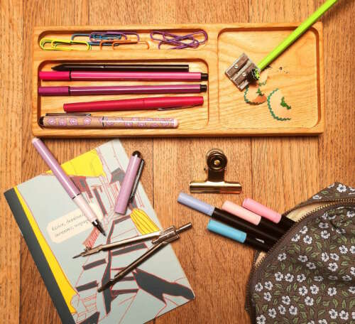 Organiseur en frêne massif fabriqué par Manufacture Dubosc et Fils, contenant des stylos, trombones et un taille-crayon, avec un carnet de notes et d'autres fournitures de bureau. Cet organiseur artisanal en bois naturel offre une solution élégante et durable pour garder votre espace de travail bien rangé. Les créations de Manufacture Dubosc et Fils allient fonctionnalité et qualité artisanale, idéales pour ceux qui recherchent une touche unique pour leur bureau.