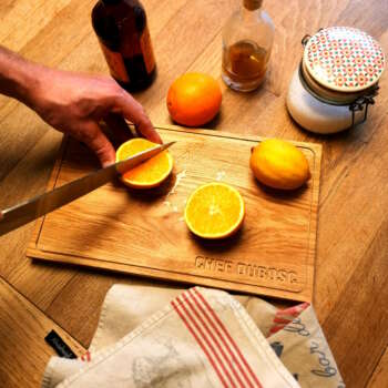 Planche à decouper personnalisé au nom du chef Dubosc en situation de coupe d'orange et de citron de Sicile