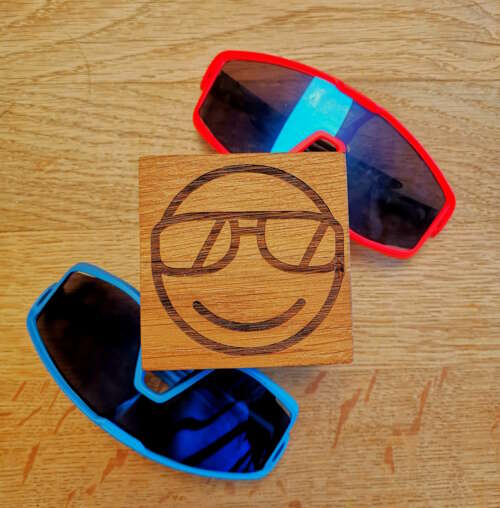 Cube en bois massif gravé avec un emoji cool portant des lunettes de soleil, fabriqué par Manufacture Dubosc et Fils. Ce cube est entouré de deux paires de lunettes de soleil, symbolisant un esprit décontracté et original. Fabriqué artisanalement à partir de bois massif, ce produit est une excellente idée pour apporter une touche amusante et personnalisée à votre décoration. Découvrez notre gamme complète d'articles en bois sur notre boutique en ligne.