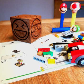 Cube smiley sur un bureau avec lego sur un bureau d'ecolier