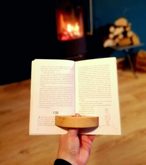 Accessoire de lecture en bois durable éco-responsable de Manufacture Dubosc et Fils, utilisé pour maintenir un livre ouvert temporairement devant un feu de cheminée. Fait main à partir de bois durable et de matériaux recyclés, cet accessoire reflète l'artisanat local et un savoir-faire traditionnel. Conception personnalisée et design intemporel, pour une fabrication artisanale de qualité supérieure et une utilisation zéro déchet Idéal pour les moments de lecture chaleureux.