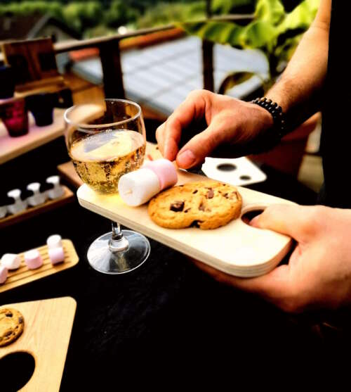 Planche apéritif en bois de contre-plaquée de Peuplier éco-responsable, faite main, avec un design fonctionnel permettant de tenir un verre à pied et des snacks. Accessoire en bois durable, fabriqué artisanalement à partir de matériaux recyclés, incarnant le savoir-faire local et une approche zéro déchet. Idéal pour des événements, avec une éthique de fabrication et un design sur-mesure