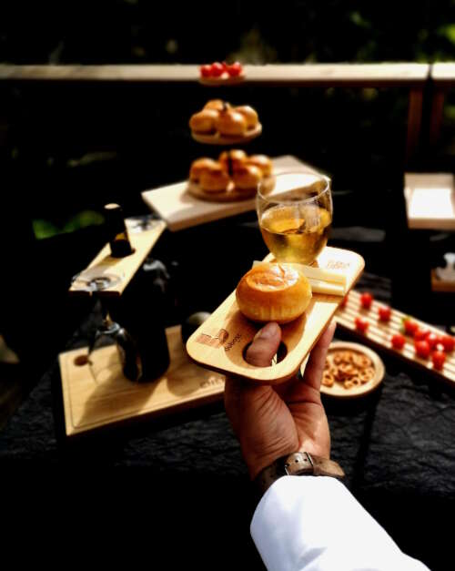 Planche apéritif en bois massif éco-responsable, faite main, avec un design fonctionnel permettant de tenir un verre à pied et des snacks, mignardises. Accessoire en bois durable, fabriqué artisanalement à partir de matériaux recyclés, incarnant le savoir-faire local et une approche zéro déchet. Idéal pour des événements, avec une éthique de fabrication et un design sur-mesure personnalisé avec QR code.