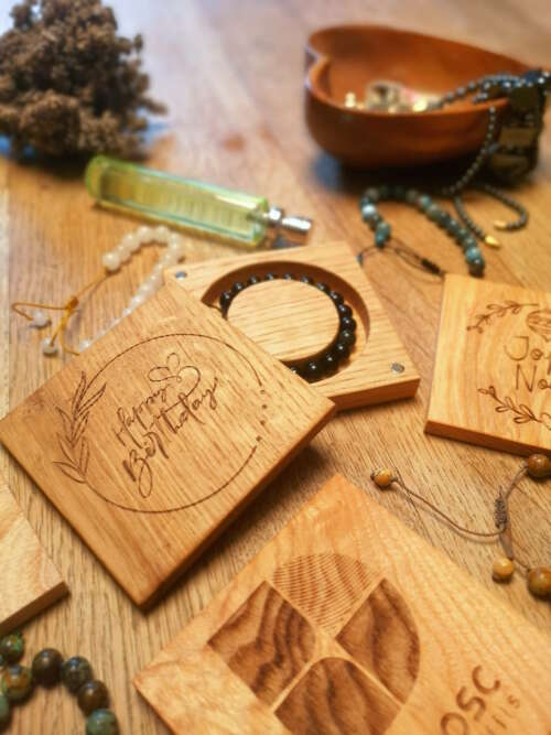 Boîtes à bracelet en bois massif personnalisables, fabriquées par Manufacture Dubosc et Fils, avec gravures 'Happy Birthday' et logo d'entreprise. Ces boîtes contiennent des bracelets en pierres naturelles, comme l'onyx noir et la pierre de lune, reconnues pour leurs bienfaits énergétiques. Idéales pour des cadeaux d'entreprise ou des événements spéciaux, ces créations artisanales en bois durable allient élégance et écoresponsabilité. Découvrez la qualité et le savoir-faire de notre boutique en ligne.