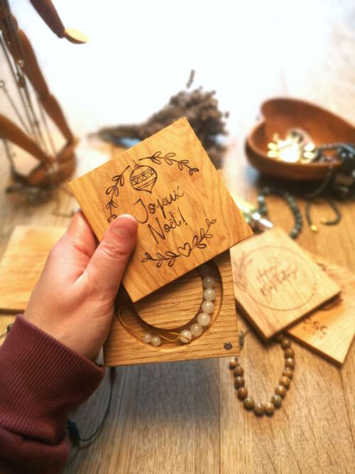 Boîte à bracelet en bois massif personnalisable, gravée du message 'Joyeux Noël', fabriquée artisanalement par Manufacture Dubosc et Fils. La boîte contient un bracelet en pierre de lune, un bijou spirituel réputé pour ses propriétés apaisantes. Parfaite pour un cadeau personnalisé et élégante, cette boîte en chêne est une création durable et raffinée, idéale pour offrir lors des fêtes. Découvrez cette pièce unique et écoresponsable sur notre boutique en ligne.