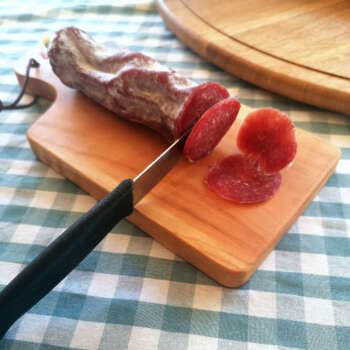 Planchette en bois de Manufacture Dubosc et Fils, utilisée pour découper du saucisson avec précision. Cette planchette artisanale en bois massif est idéale pour les apéritifs et les moments de partage, offrant une touche naturelle et élégante aux tables conviviales.