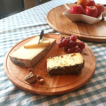 Plateau tournant en bois massif de 35 cm de Manufacture Dubosc et Fils, présentant un assortiment de fromages, raisins, et noix. Ce plateau est idéal pour les présentations de table élégantes et conviviales, parfait pour les amateurs de charcuterie et de fromage souhaitant ajouter une touche artisanale à leurs repas.