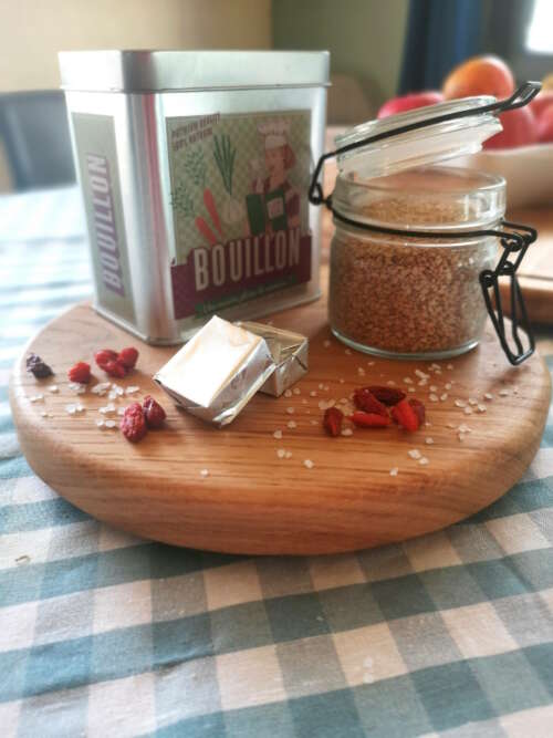 Plateau tournant en chêne massif de Manufacture Dubosc et Fils, utilisé pour présenter des ingrédients de cuisine comme des cubes de bouillon, des baies de goji, et des graines de sésame. Ce plateau en bois naturel est un accessoire élégant et pratique pour les tables conviviales, idéal pour organiser et servir des éléments culinaires avec style.