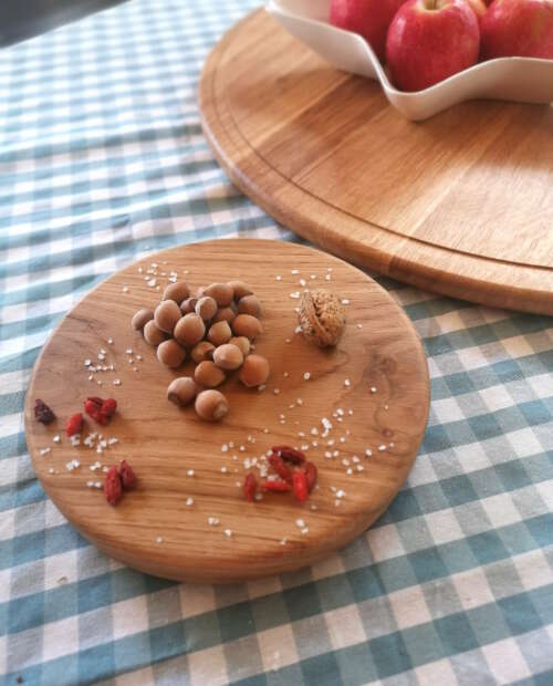 Petit plateau tournant en chêne massif de Manufacture Dubosc et Fils, orné de noisettes, de baies de goji et de gros sel. Ce plateau en bois naturel est parfait pour des présentations élégantes et conviviales, idéal pour organiser vos apéritifs ou ingrédients de manière raffinée.