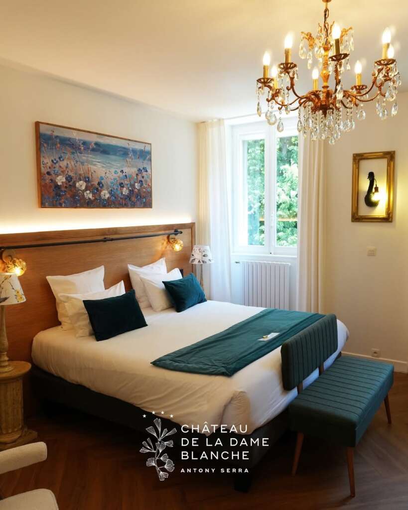 Chambre d’hôtel raffinée avec mobilier sur mesure en bois massif, réalisée par la Manufacture Dubosc et Fils au Château de la Dame Blanche.