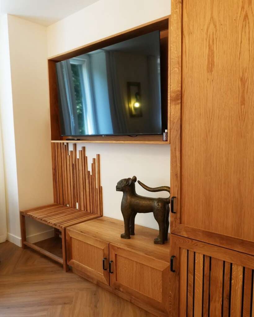 Meuble TV en chêne massif avec assise sculpturale intégrée, design contemporain et lignes graphiques.