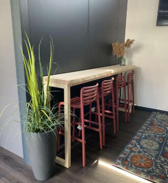 Table de bar mange-debout en bois massif clair avec tabourets design rouges