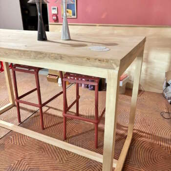 Table mange debout en bois massif assortie à des tabourets rouges – ambiance chaleureuse.