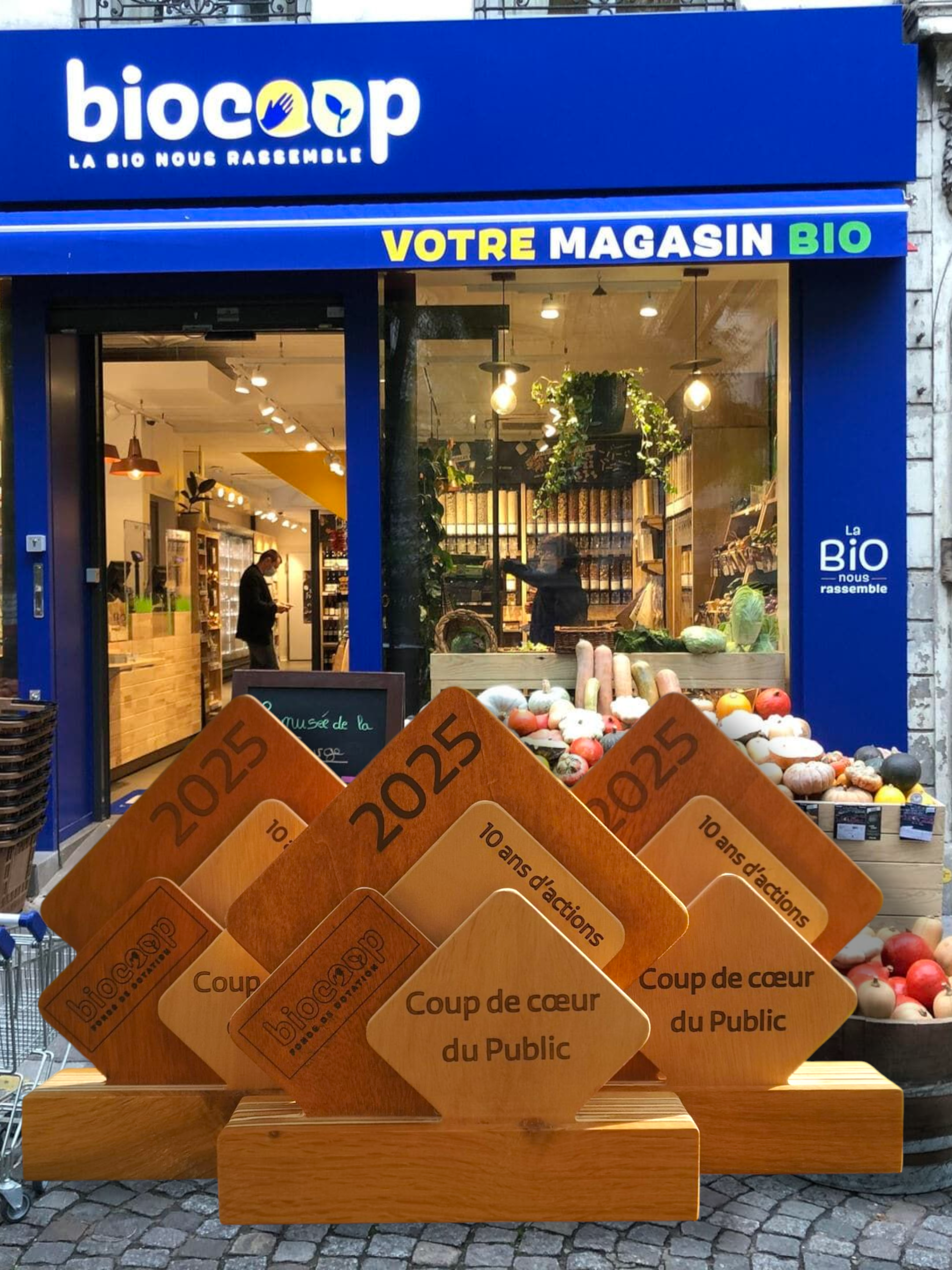 Trophée Biocoop 2025 en bois massif exposé devant un magasin Biocoop – création artisanale Manufacture Dubosc & Fils.