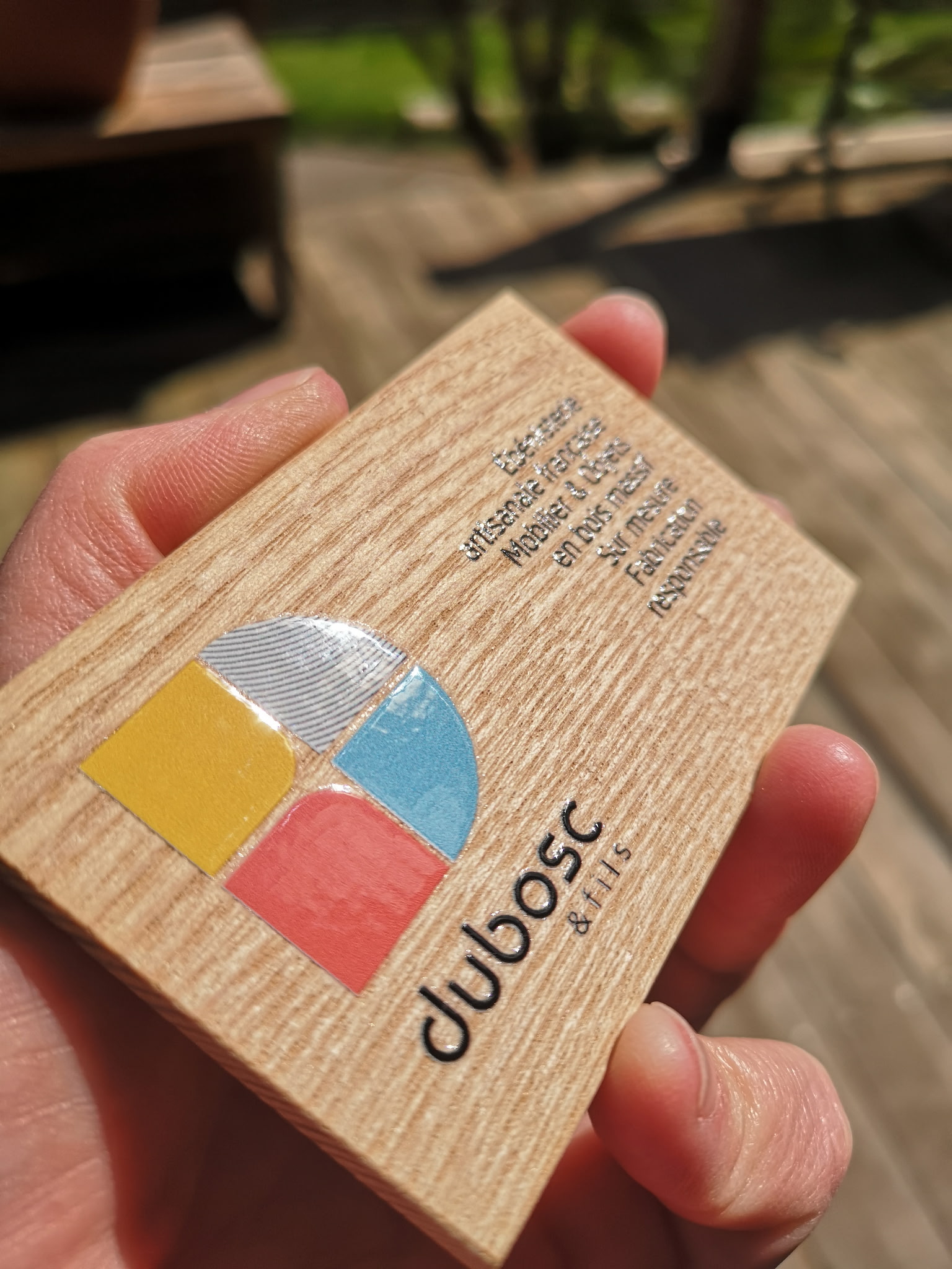 Carte de visite bois personnalisée avec logo couleur et gravure laser artisanale.